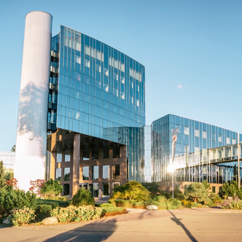 The BED Business Park in Ehingen: on the left, a tower; on the right, another building with a glass facade in which the sun is reflected.